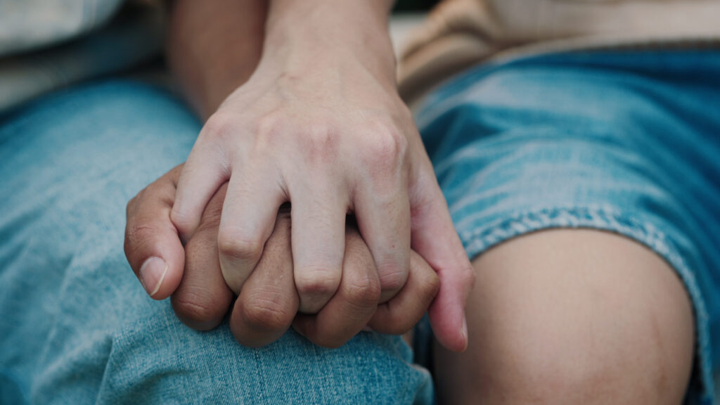 close-up-of-two-male-hands-gently-touching-and-holding-each-other-showcasing-a-cute-qu-SBI-351519401